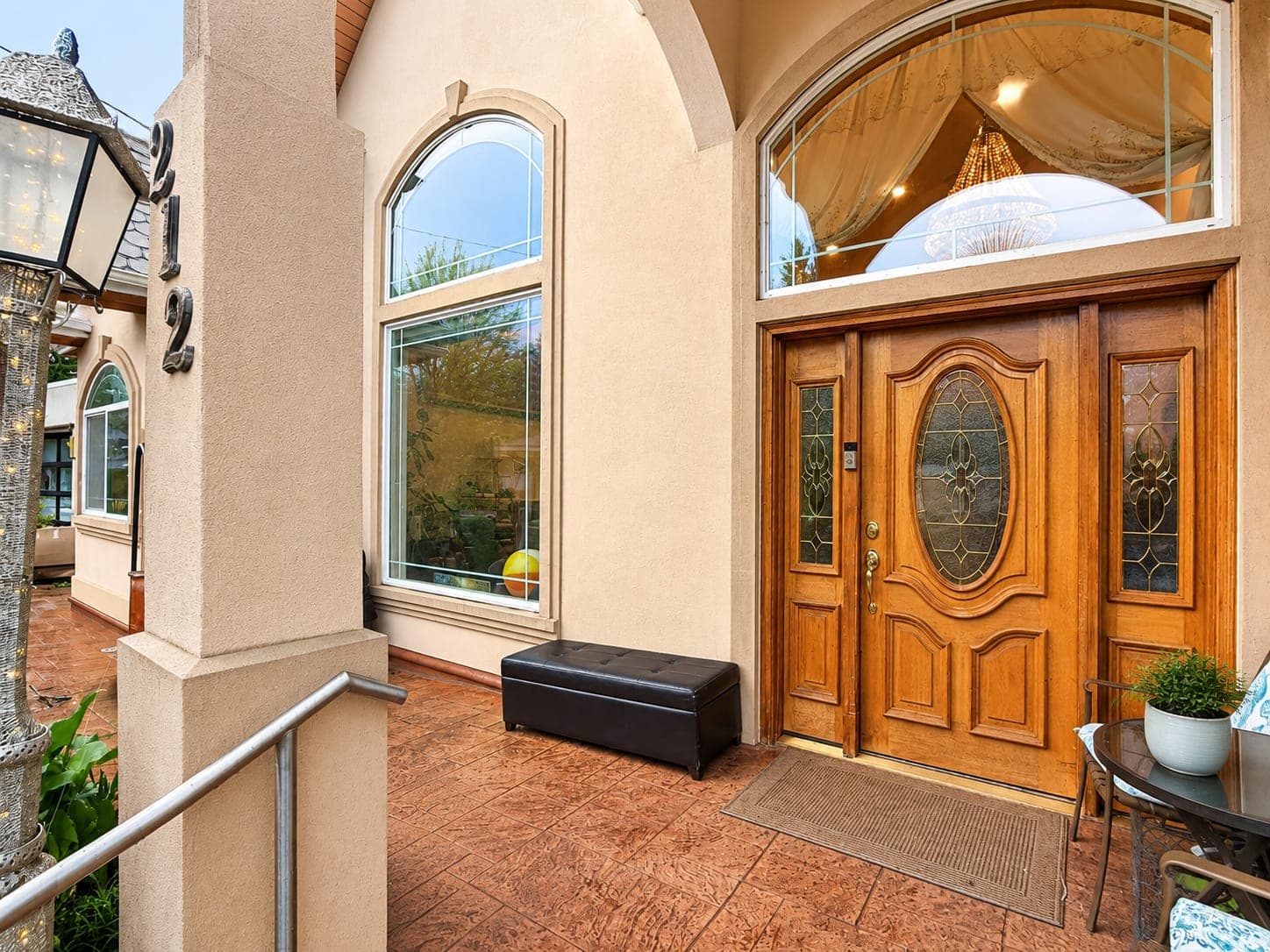 The front door — a carved wooden door with an arched window above it.